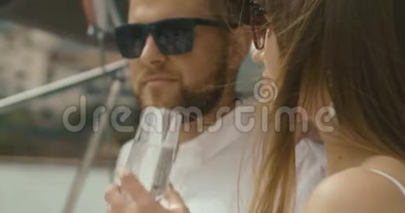 恋爱中的情侣在游艇上放松男人和女人穿着白色衣服彼此温柔拥抱喝香槟视频的预览图