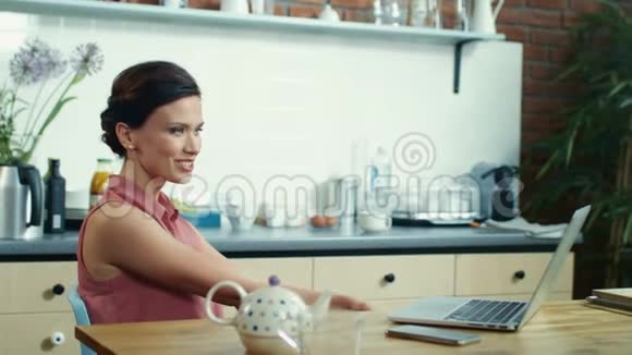 在厨房有视频通话的女人女性在网络摄像头上打招呼视频的预览图