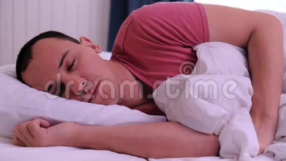 男人睡在白色的枕头上他醒过来睁开眼睛视频的预览图