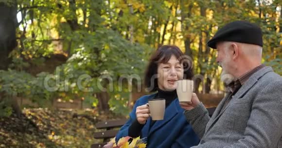 近距离观看妻子和丈夫在市中心公园喝茶并就各种话题进行交流快乐视频的预览图