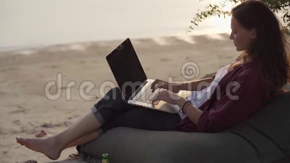 带着笔记本电脑在热带海滩工作的女孩视频的预览图
