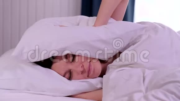 女青年睡觉时被吵闹的坏邻居用枕头捂住耳朵醒来躺在床上受苦视频的预览图
