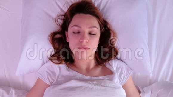 美丽的少女睡在白色的枕头上视频的预览图