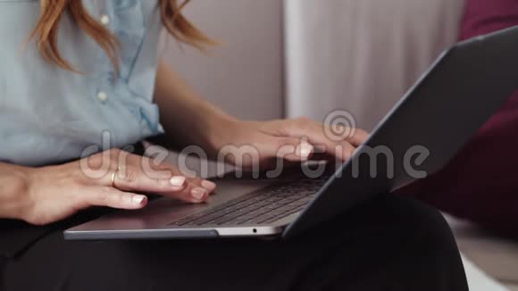 女性手在远程办公室的笔记本电脑上打字女孩在写笔记本视频的预览图