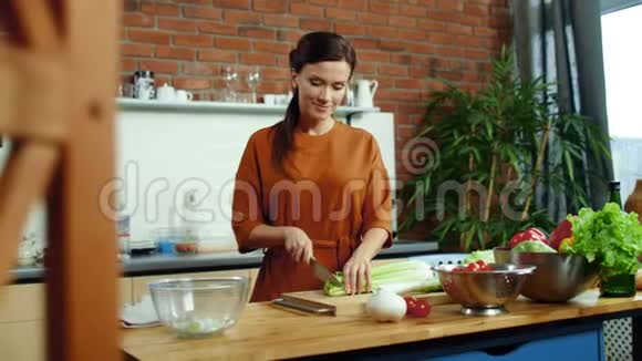 女人在厨房里切蔬菜做沙拉家庭主妇做健康的饭菜视频的预览图