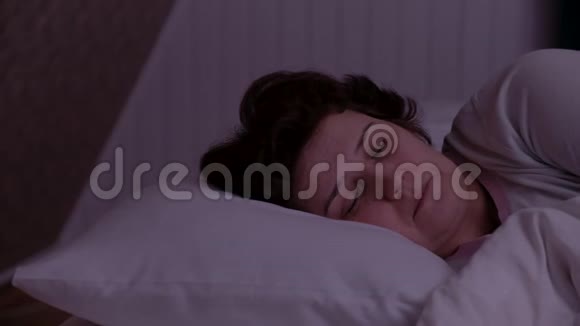 成年妇女晚上睡在白色枕头上视频的预览图