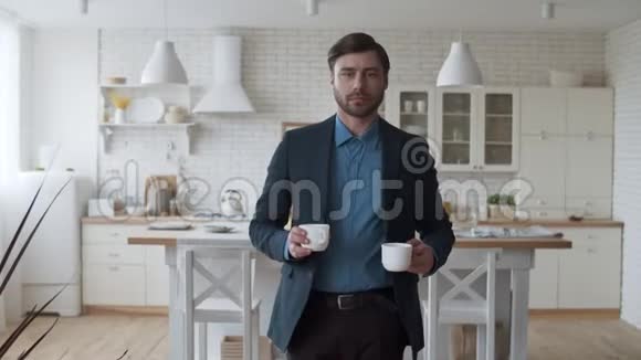 充满爱的一对夫妇在家里泡咖啡男人带着茶杯给妻子视频的预览图