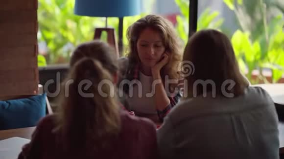 坐在咖啡店里享受咖啡谈话的朋友们视频的预览图
