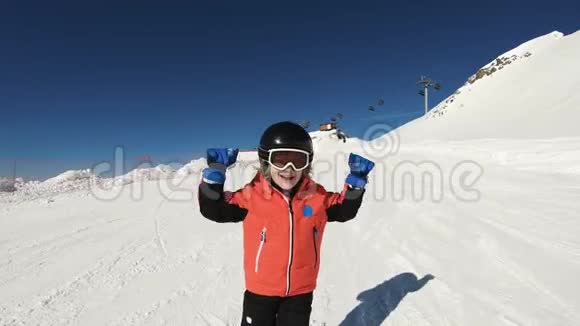 微笑的孩子滑雪在雪山上挥着手视频的预览图