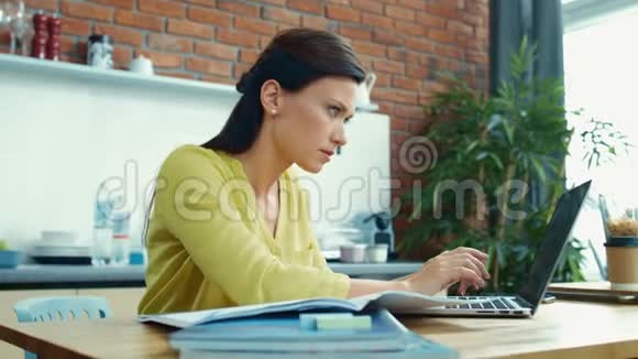 女商人在家里做笔记本电脑烦人的女孩在厨房休息视频的预览图