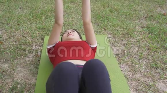 年轻健康快乐的亚洲女子做仰卧起坐运动视频的预览图