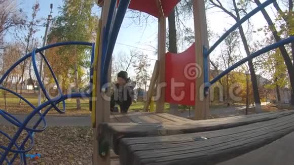 一个可爱的小男孩在公园的操场上玩耍花时间在户外很有趣视频的预览图