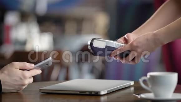 服务员的手特写镜头他用手机上的应用程序在餐厅接受支付晚餐费用视频的预览图
