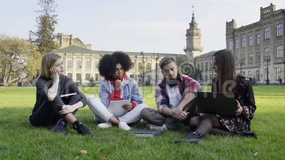 4大学校园草地上的学生用笔记本电脑视频的预览图