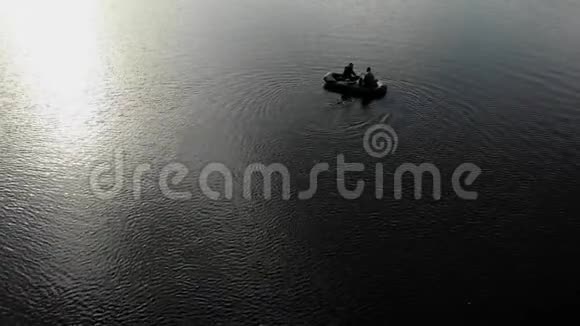 日落时两个人的船浮在河上视频的预览图
