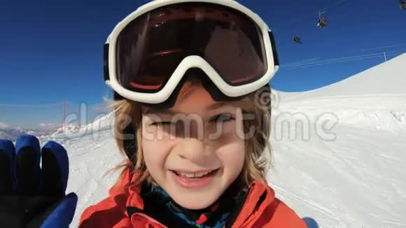 微笑的孩子滑雪在雪山上挥着手视频的预览图