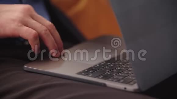 特写男手在家庭办公室的笔记本电脑键盘上慢动作打字视频的预览图