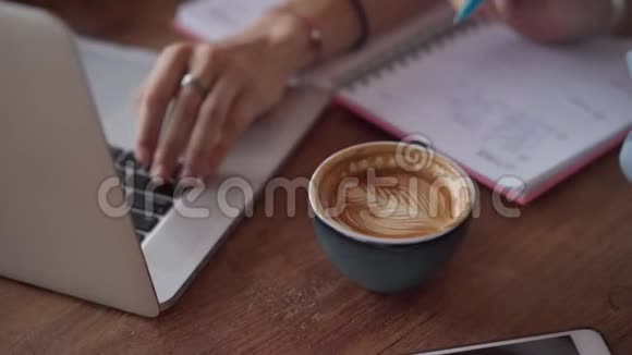 在户外咖啡厅与笔记本电脑合作的快乐女性朋友特写视频的预览图