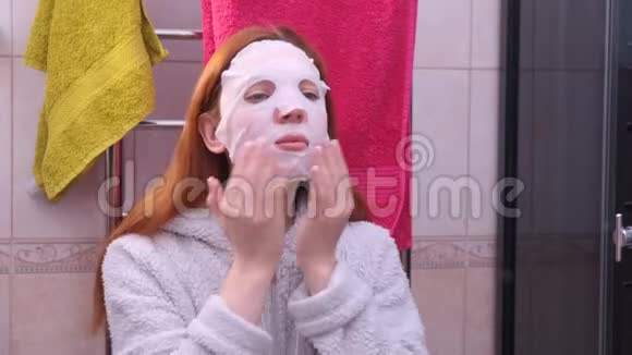 年轻女子在照镜子时脸上戴着化妆面具视频的预览图
