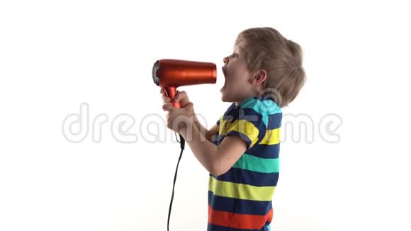演播室里的小男孩在一个白色背景下摆弄着吹风机对着麦克风尖叫视频的预览图