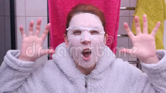 一个戴着化妆面具的女人吓了一跳戴着面具很有趣视频的预览图