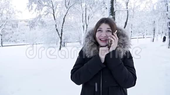 一个女人在寒冷的冬天打电话冬天下雪视频的预览图