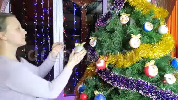 4K视频美丽的年轻女孩装饰圣诞树与鲍布和花环在客厅家庭装饰屋视频的预览图
