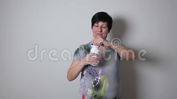 女人在拿着水瓶的年龄喝水微笑健身妇女在锻炼后休息视频的预览图