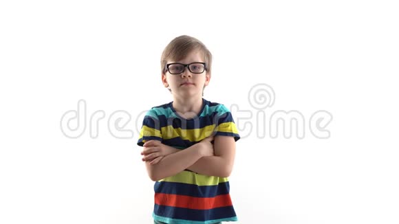 一个严肃的男孩在白色背景上的工作室肖像带眼镜的一年级学生视频的预览图