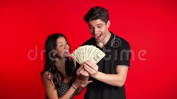 满意的欧洲夫妇显示货币美元纸币上的红色视频的预览图