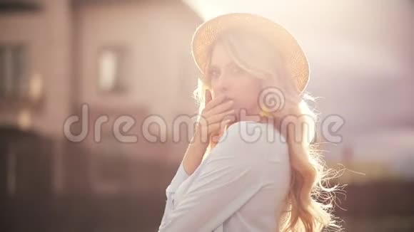 戴着夏帽的漂亮女孩在阳光下摆姿势视频的预览图