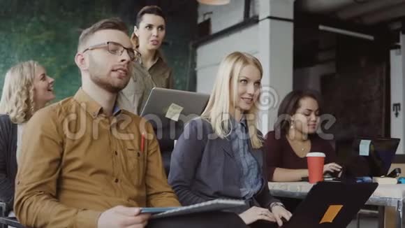 快乐混合种族的人在阁楼办公室带笔记本电脑的男人和女人带平板电脑的视频的预览图