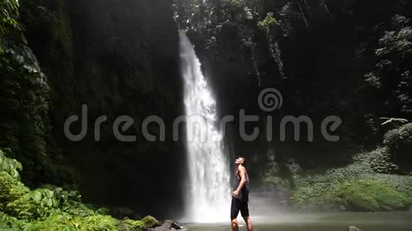 令人惊叹的塞库普尔瀑布巴厘岛慢动作录像热带植物前景的流动相机视频的预览图