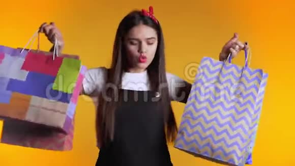 一位年轻快乐的女士在买完黄色的东西后带着五颜六色的纸袋视频的预览图