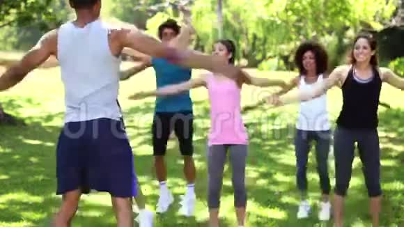 健身课在公园里做跳跃的杰克视频的预览图