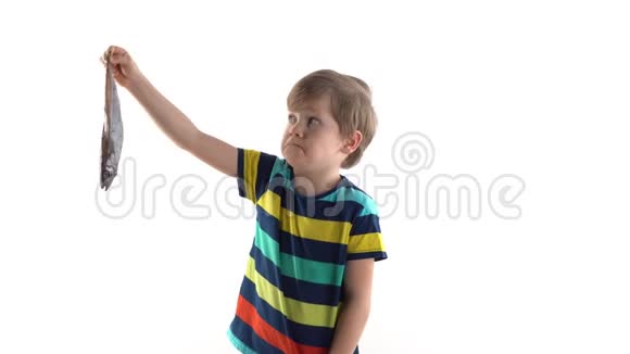 一个男孩在画室里摆着一个白色背景和生鱼露出厌恶的表情视频的预览图