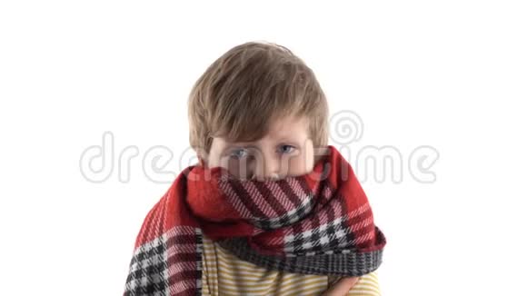 一个寒冷的小男孩被一条温暖的围巾裹在白色背景的工作室里的肖像视频的预览图