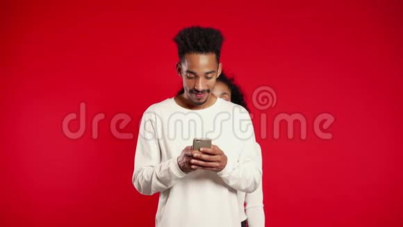 非洲女孩偷看男友的肩膀他通过手机交流视频的预览图