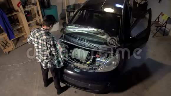 男的正在修理车库里的汽车发动机视频的预览图