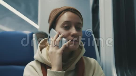 火车上迷人的微笑女孩用智能手机与朋友聊天的照片女性手部互联网技术手机城市m视频的预览图