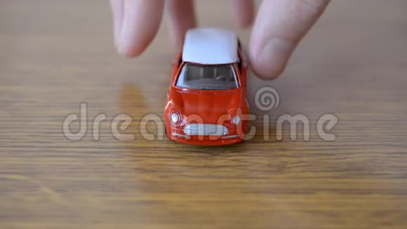 木制桌子上的红色玩具车视频的预览图