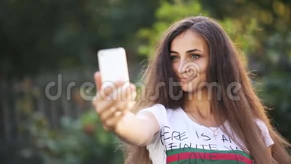 开朗的女人用智能手机自拍视频的预览图