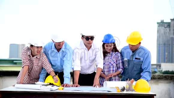 施工工程师团队合作安全套装信任团队在施工现场持有白色黄色安全安全帽安全设备视频的预览图