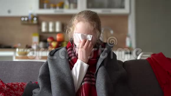 冷白种人女孩在家一个穿着围巾格子花格子的生病孩子在公寓沙发上的肖像那个女学生视频的预览图