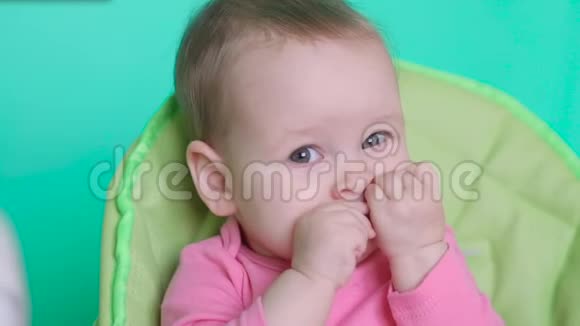 小女孩坐在厨房儿童椅子上吃着一个多汁的梨视频的预览图