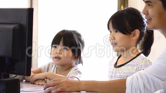 亚洲父亲和可爱的女儿玩电脑视频的预览图