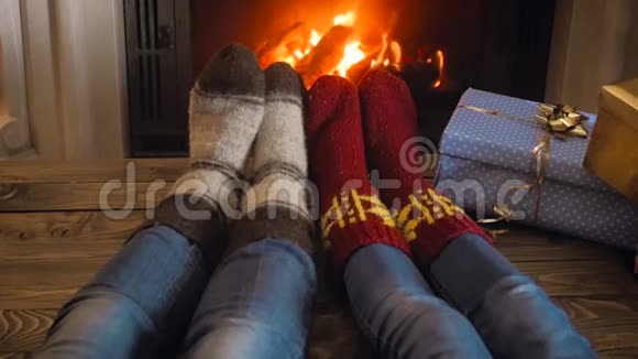 一对穿着羊毛袜的夫妇在平安夜的壁炉前度过浪漫之夜的慢镜头视频的预览图