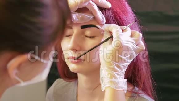 美容师把多余的指甲花从顾客的眉毛上洗掉视频的预览图