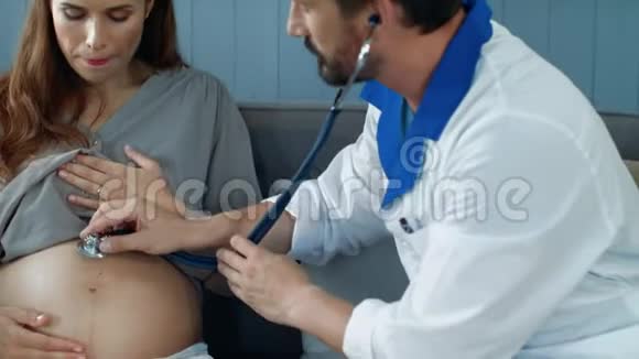 产科医生用听诊器倾听孕妇腹部的肖像视频的预览图