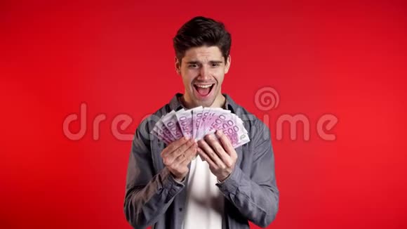 穿着衬衫的男人脸上带着惊讶的快乐拿着美国货币有钱的人视频的预览图